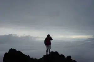 An adventurer looking out at mountains, the spirit of exploration in the site name